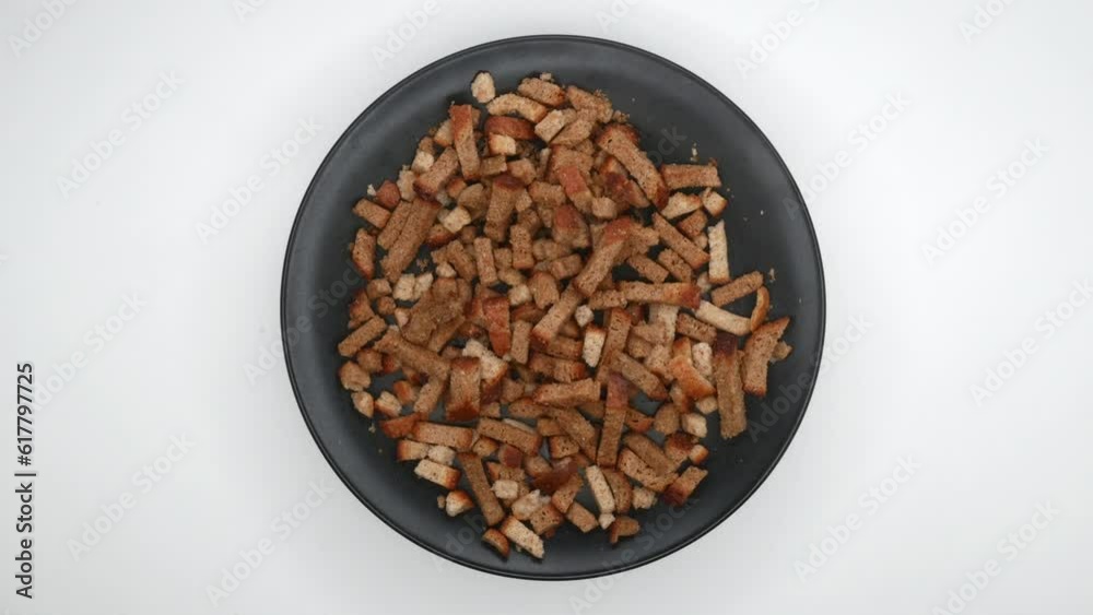 Rye Crackers Rotating On White Background. Bread Crispy Crackers Rotated On A Black Flat Plate. Top View. 4k. Rye Crackers Rotating On White Background. Bread Crispy Crackers Rotated On A Black Flat Plate. Top View. 4k.