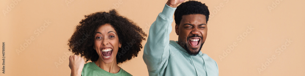 Black man and woman laughing and gesturing as winners Black man and woman laughing and gesturing as winners