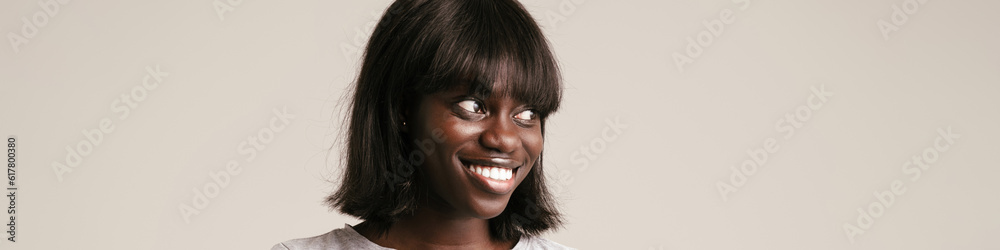 Young beautiful smiling african woman with phone looking aside Young beautiful smiling african woman with phone looking aside
