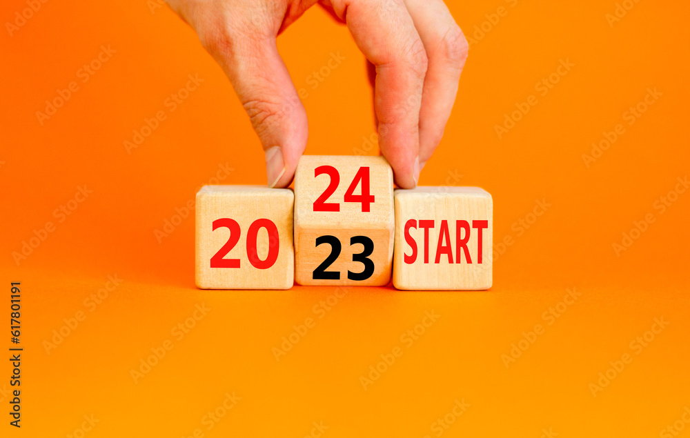 2024 start new year symbol. Businessman turns a wooden cube and changes