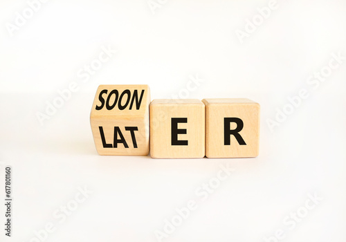 Sooner or later symbol. Businessman turns wooden cubes and changes the word Later to Sooner. Beautiful white table white background. Copy space. Business and sooner or later concept.