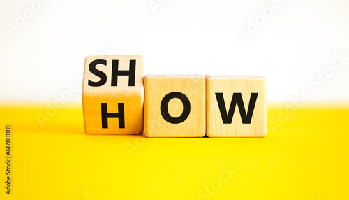 Show how symbol. Businessman turns wooden cubes and changes the word Show to How. Beautiful yellow table white background. Copy space. Business and Show how concept.