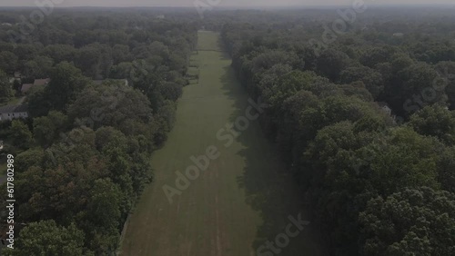 Drone Shot of a long stretch of grass surrounded by trees. photo