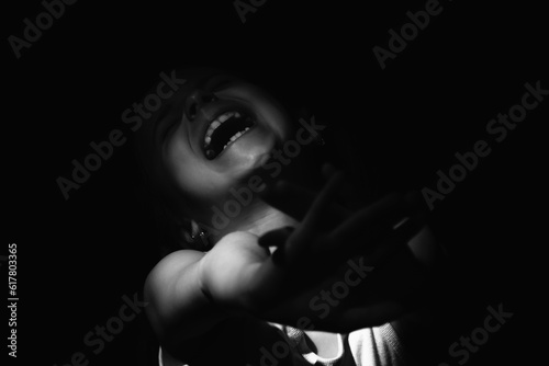 Conceptual image: Protect children and young underage people from violence, exploitation, abuse, and neglect. Syluette of upset young child girl craying and showing with hands stop gesture.