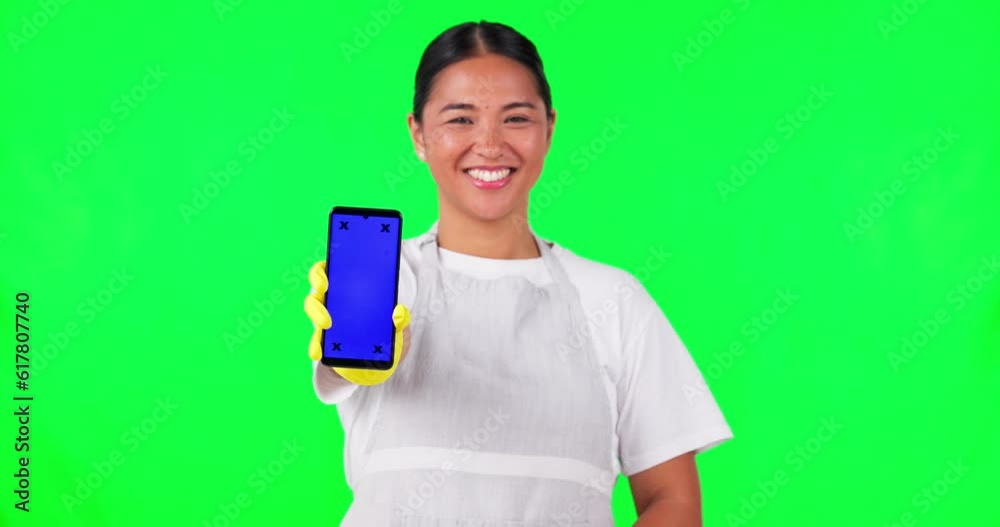 Asian woman, housekeeper and phone mockup on green screen in advertising against a studio background. Portrait of happy female person, maid or cleaner show mobile smartphone app with tracking markers Asian woman, housekeeper and phone mockup on green screen in advertising against a studio background. Portrait of happy female person, maid or cleaner show mobile smartphone app with tracking markers