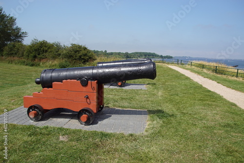 View on the large Zeeland lake called Veerse Meer with a cannons in the grass ashore and a path. Near the Dutch city of Veere. Ships in the distance. Summer. Netherlands, June  photo