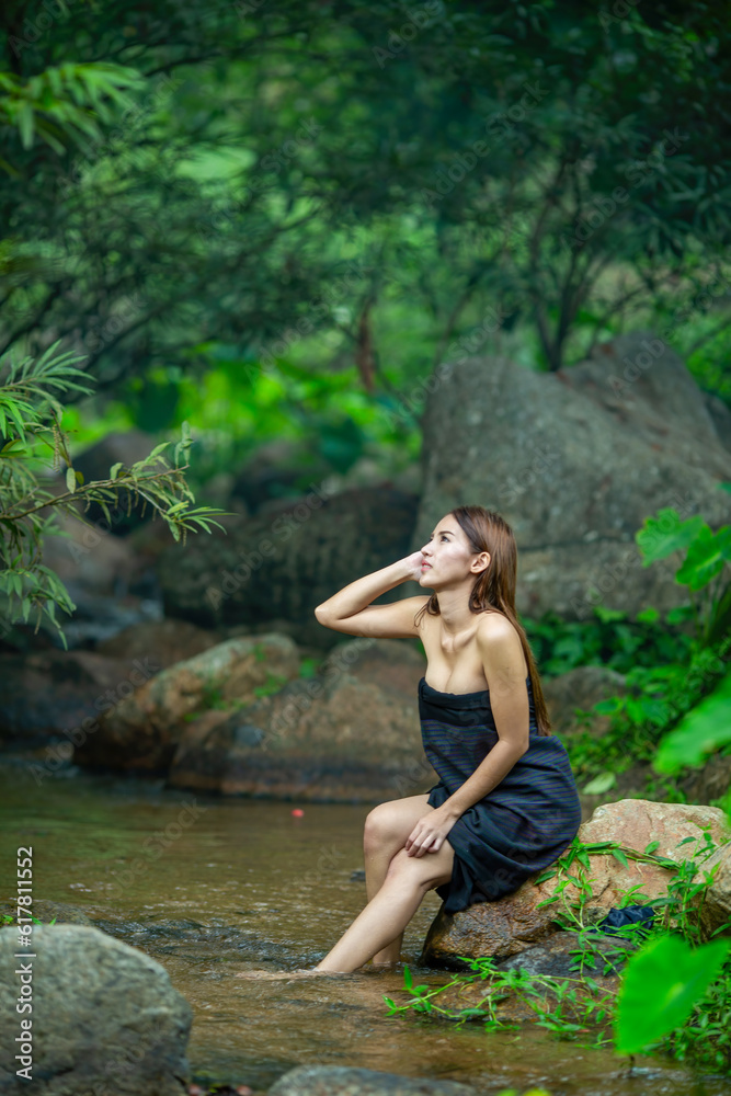 Beautiful Woman asia slim fitness model posing sexy in creeks wearing Sarong shower and wash a clothes in the stream from the waterfall to show the lifestyle of people in the countryside with nature Beautiful Woman asia slim fitness model posing sexy in creeks wearing Sarong shower and wash a clothes in the stream from the waterfall to show the lifestyle of people in the countryside with nature