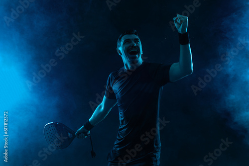 Padel tennis tour player. Man athlete with paddle tenis racket on black background. Sport concept. Download a high quality photo for sports website.