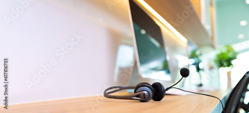 Konstfotografi headset on desk with computer desktop at customer service and marketing support workplace