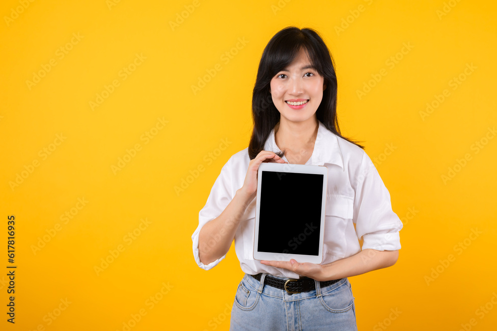 Confident asian woman embraces the digital age, holding tablet on a vibrant yellow background. modern connectivity, tech-savviness, and empowerment. digital lifestyles and technological advancements. Confident asian woman embraces the digital age, holding tablet on a vibrant yellow background. modern connectivity, tech-savviness, and empowerment. digital lifestyles and technological advancements.