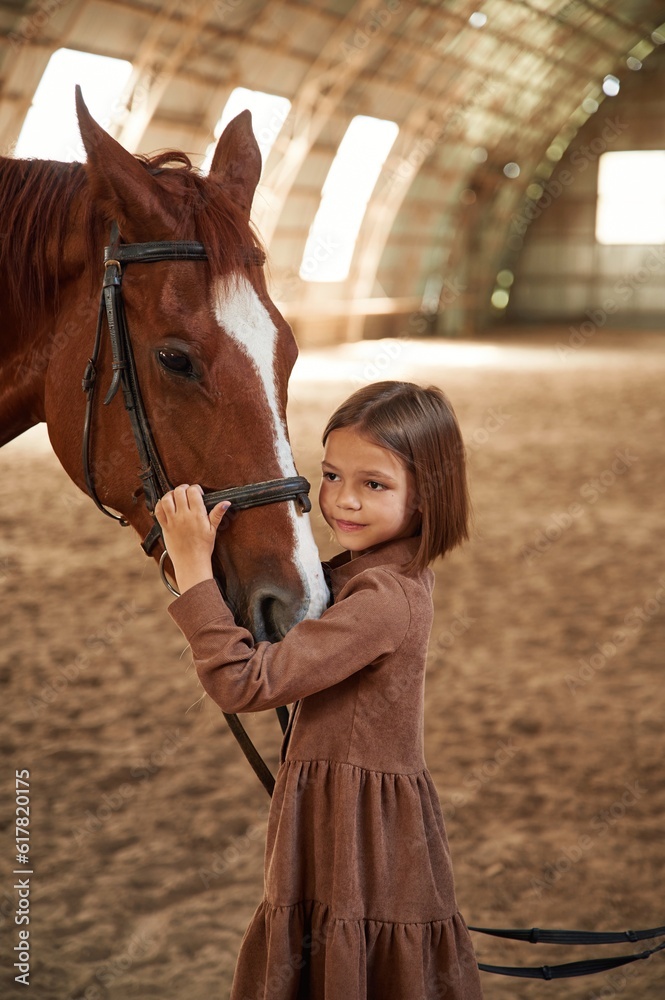 Obraz premium Embracing the animal. Cute little girl is with horse indoors