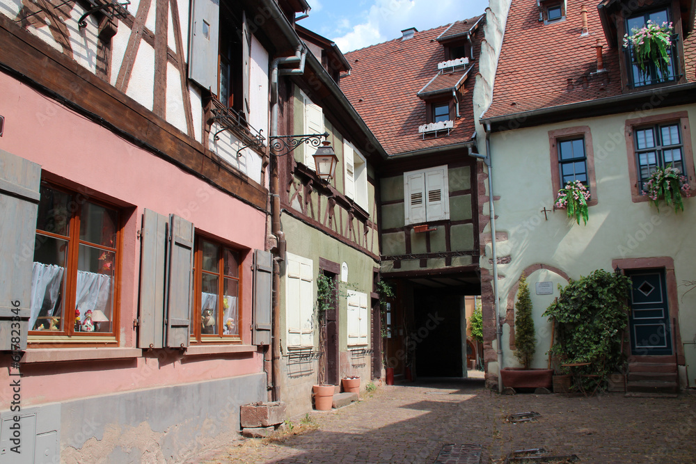courtyard and half-timbered houses in riquewihr in alsace (france)