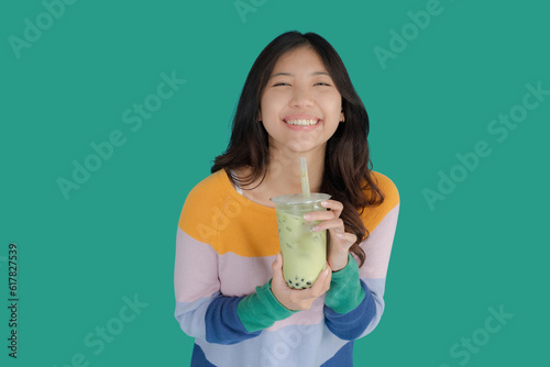 Beautiful young woman smiling happily while holding bubble tea in her hand