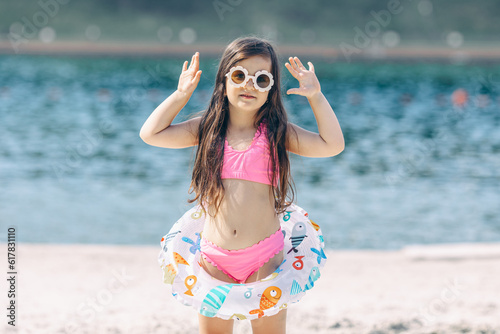 Cute little girl has a fun on the beach. Summertime concept.