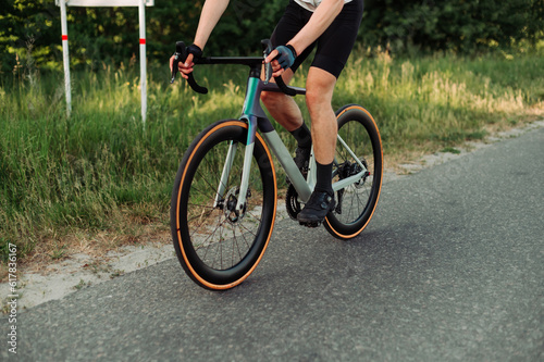 Close up photo. A man rides a road bike on a country road. © bodnarphoto
