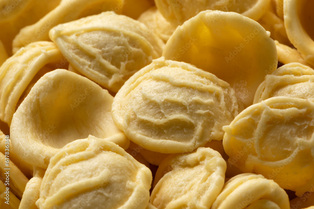 Uncooked Orecchiette pasta close up full frame as background Uncooked Orecchiette pasta close up full frame as background