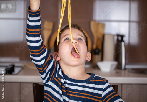 happy beautifl kid eat spaghetti photo