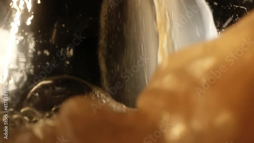 Slow motion beer soda pouring inside glass