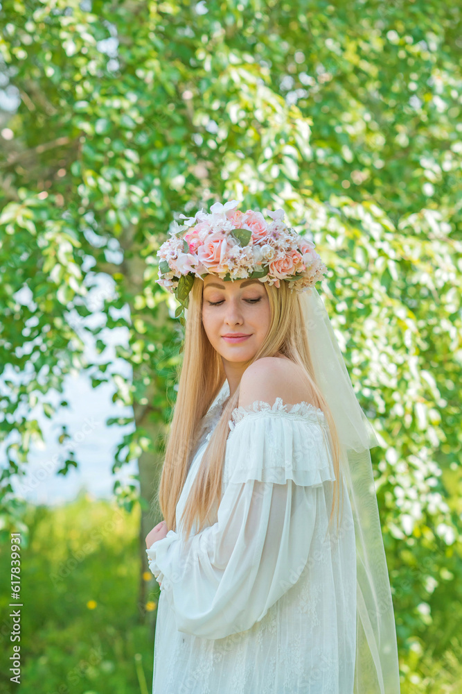 Fototapeta premium European Slavic Tradition, bride woman in white dress, flower wreath with a veil on a head. Tender girl