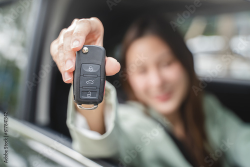 Close-up hands of a woman excitement, showcasing her brand new car key and confident posture radiate a sense of accomplishment and success.