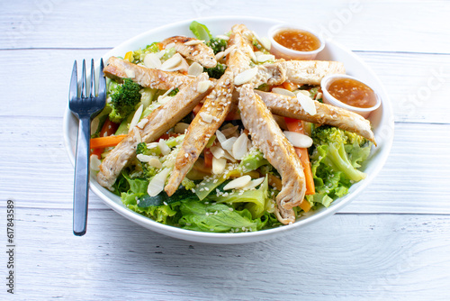 Fresh healthy chicken salad with sesame, lettuce, cucumber in sweet and sour sauce