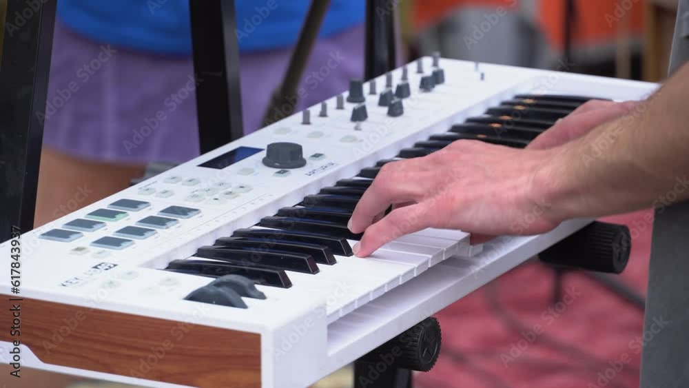Musician playing the synthesizer at a street music festival. Cover band performing at open air, Keyboardist synthesizer playing
