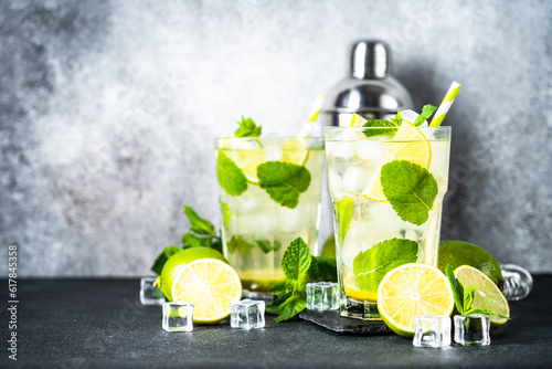 Mojito with rum, mint and lime on black background. Tradition Summer drink with shaker and bar utensils.