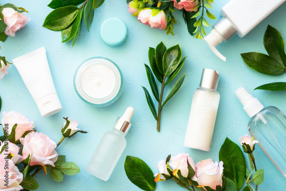 Natural cosmetic products on blue background. Cream, serum, tonic with green leaves and flowers. Skin care concept. Natural cosmetic products on blue background. Cream, serum, tonic with green leaves and flowers. Skin care concept.