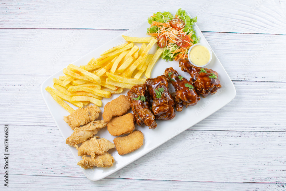 Chicken mix, wings in bbq sauce, nuggets and chicken pieces, accompanied by French fries, salad and mayonnaise