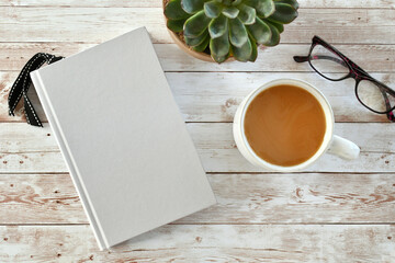Blank 5.5x8.5 book cover for mock up with coffee, plant and reading glasses.