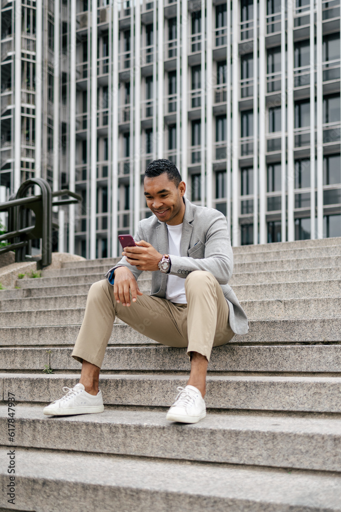 Man sitting on stairs using smartphone