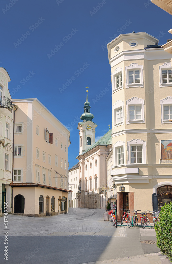 View into Linzer Gasse of Salzburg in Austria. Main pedestrian artery through the historical district on the right side of the river Salzach, with houses from 14th century and the St Sebastian church.