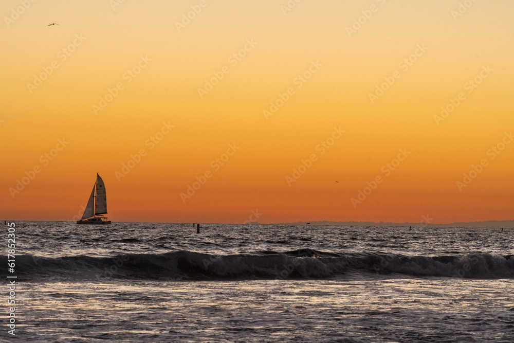 Sailboat on the Pacific Ocean at sunset off the beach in Santa Monica, California