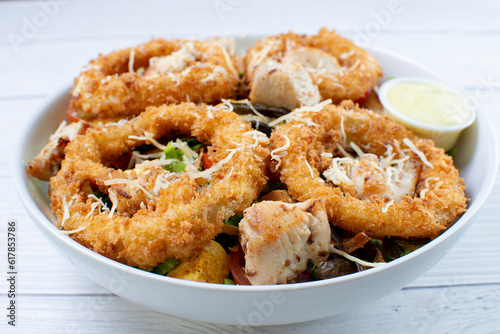 Obraz na płótnie Bowl salad with pieces of roast pork, grated cheese, onion rings and house mayonnaise w salonie