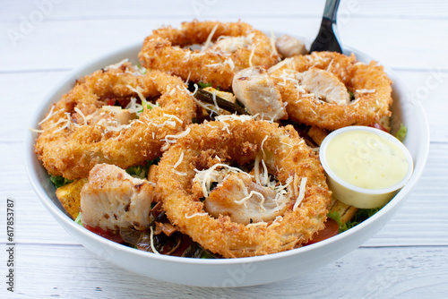 Obraz na płótnie Bowl salad with pieces of roast pork, grated cheese, onion rings and house mayonnaise w salonie
