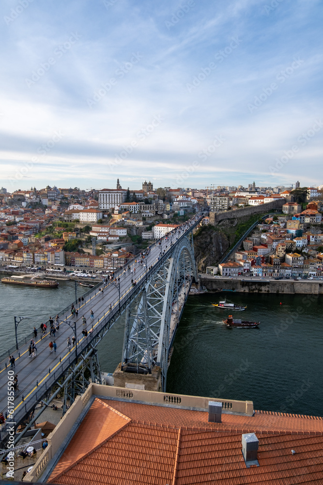 la belleza de Oporto, Portugal, con el emblemático puente de Don Luis como protagonista. En la imagen, el puente de hierro se extiende majestuosamente sobre el río Duero, conectando las dos orillas de