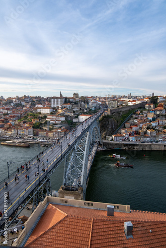 la belleza de Oporto, Portugal, con el emblemático puente de Don Luis como protagonista. En la imagen, el puente de hierro se extiende majestuosamente sobre el río Duero, conectando las dos orillas de