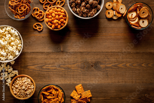 Many bowls with different salty snacks - chips pretzels nuts