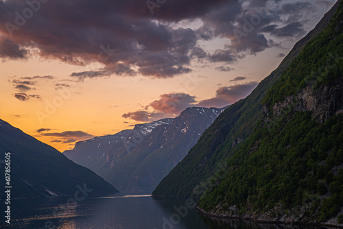 Dramatic colorful twilight summer sunset on the Geiranger fjord in Norway with vibrant clouds steep cliffs and waterfalls photo