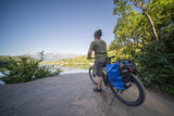 A tourist on an electric trekking bike admires the view of Lake Monticolo in northern Italy