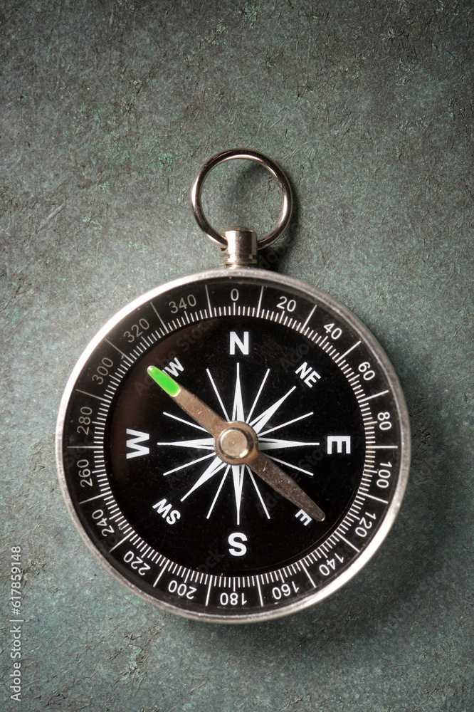Close-up of a compass on a green surface Close-up of a compass on a green surface