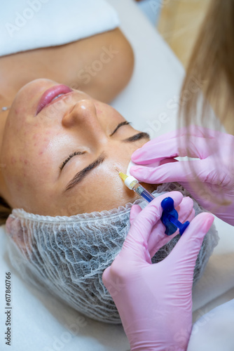 Cosmetologist doing injections to woman's face, skin treatment. photo