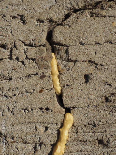 Mounting foam - polyurethane foam sealant. The foam consists of 2 main components, Methylene diphenyl diisocyanate and polyols. Foam-filled crack in the plastered wall of the facade of the house. photo