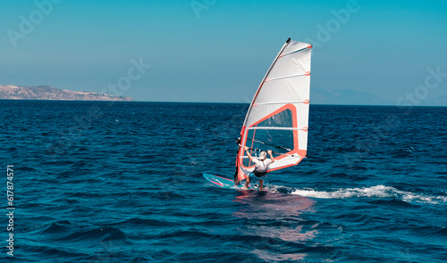 man doing wind surf in the sea, sunny summer day, water sports outdoor activity