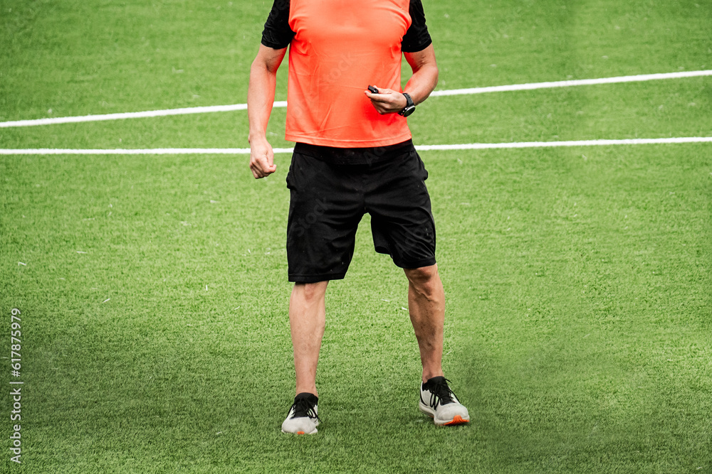 anonymous soccer referee in the middle of the soccer field anonymous soccer referee in the middle of the soccer field
