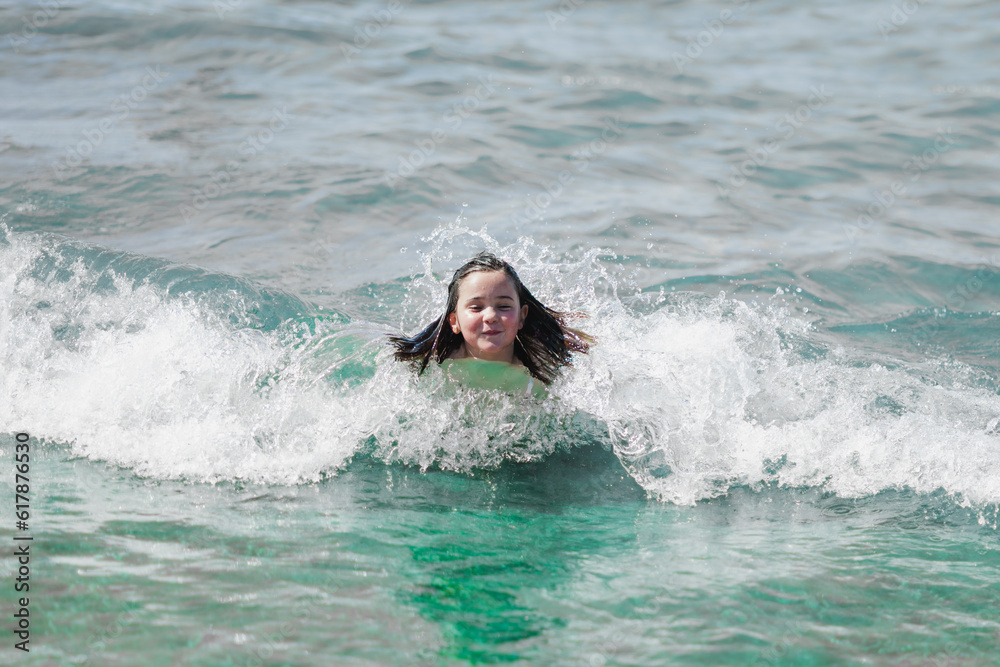 adorable girl plays in the sea by the shore