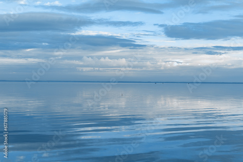 White blue clouds over lake  symmetric sky and water background  cloudscape on lake. Nature abstract  cloudy sky reflected on water  calm tranquil concept  aesthetic panoramic view