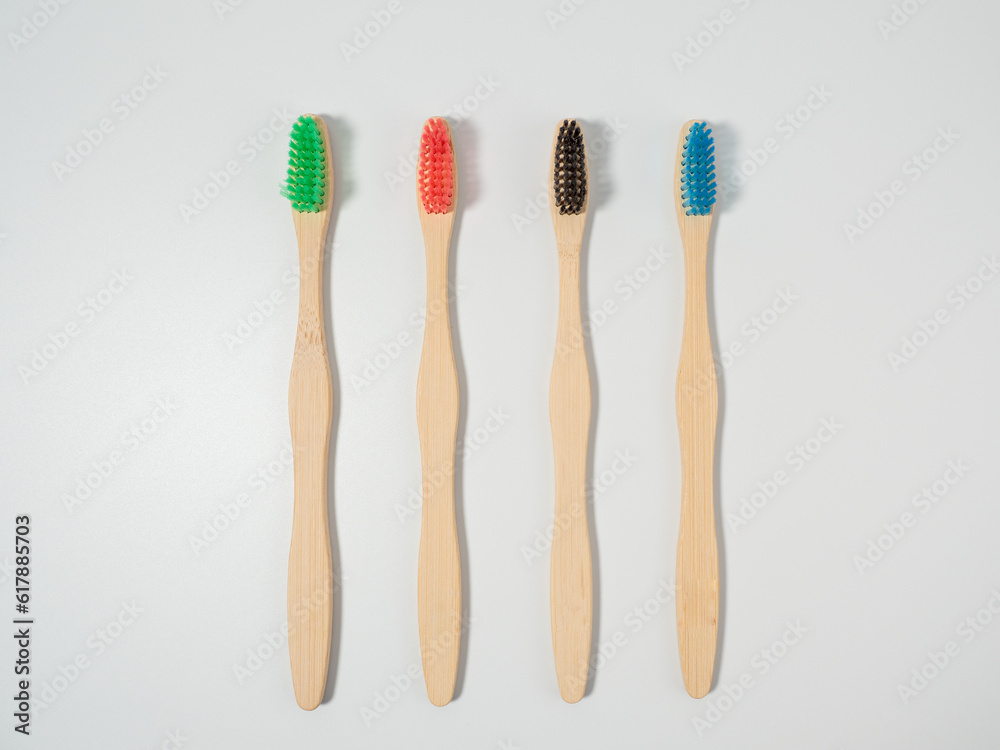 Bamboo toothbrushes in different colors. Wooden toothbrush on a white background. Toothbrush close-up. Bamboo toothbrushes in different colors. Wooden toothbrush on a white background. Toothbrush close-up.