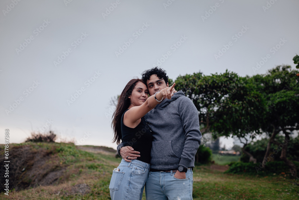 Photograph of young couple looking at the horizon on a cloudy afternoon. Concept of people and lifestyles. Photograph of young couple looking at the horizon on a cloudy afternoon. Concept of people and lifestyles.