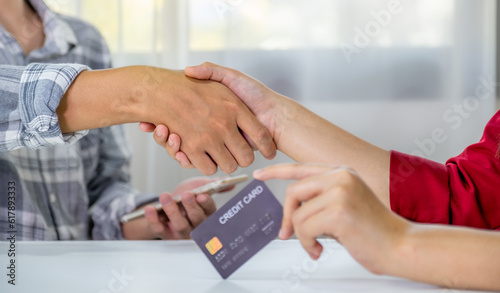 handshake. Young couple consumer holding mock up credit card, Ready to spend pay online shopping according to discount products via smartphone and laptop from home office